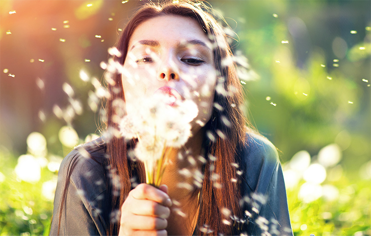 Femme qui souffle des fleurs